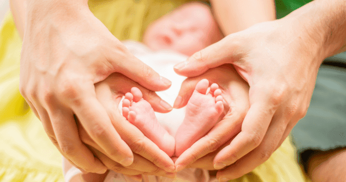 parent holding baby's feet