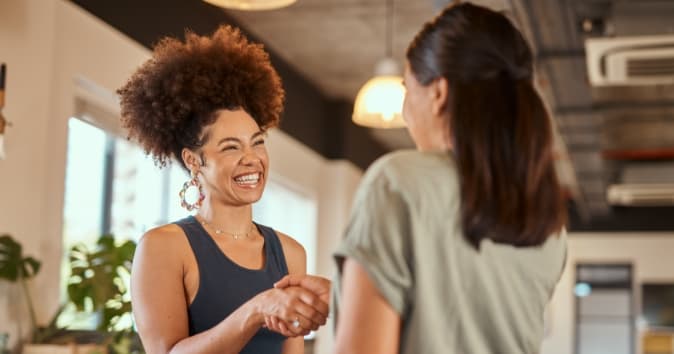 Two women shaking hands.