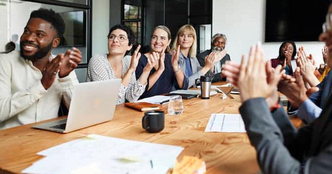 people sitting around the table and clapping