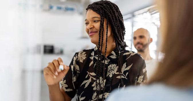 women smiling and holding pen
