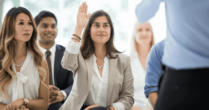 A female employee asking a question during a training and mentorship program