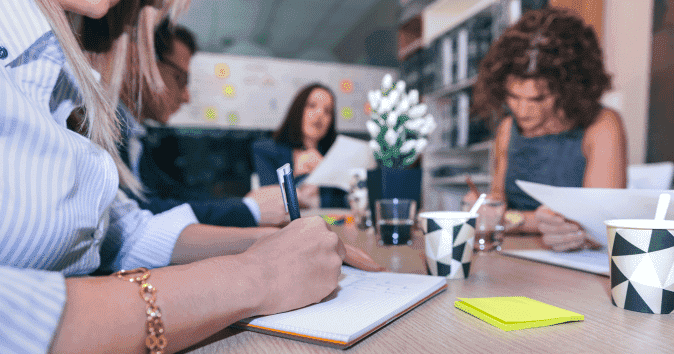 close-up of a female employee writing meeting notes