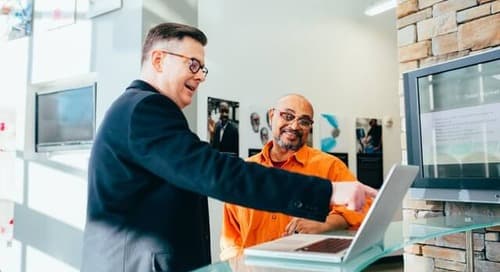 two people looking at a laptop