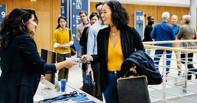 Women handing out visiting cards to attendees