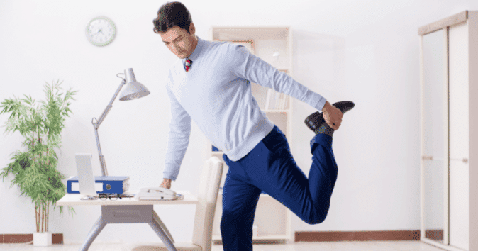 A man stretching his arms to reduce stress and improve office well-being