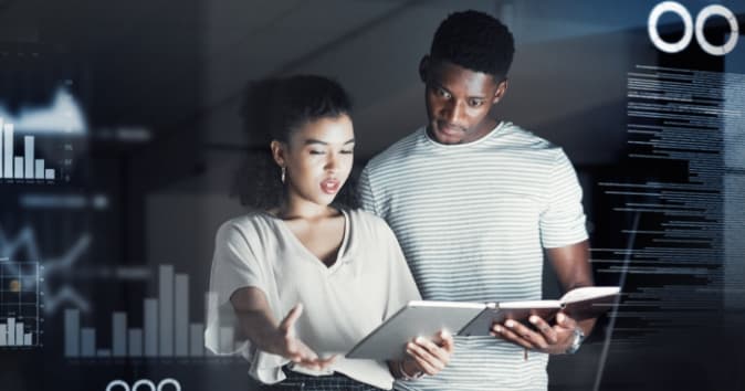 Two people looking at notes with digital information all around them.