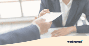 two people handing an envelope over a table