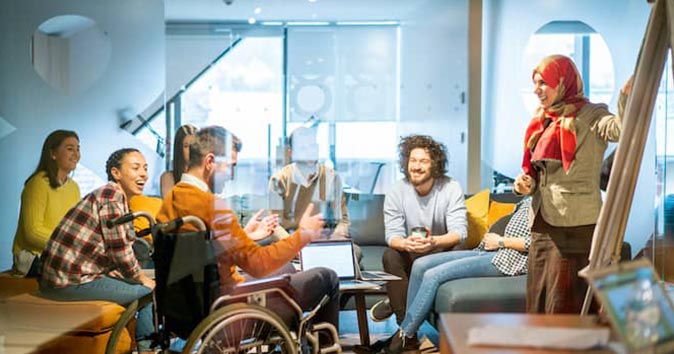 A group of employees sitting together and discussing and laughing.
