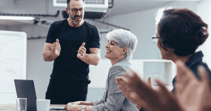 Team clapping for an employee as an expression of appreciation and encouragement