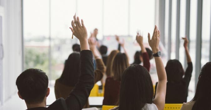 People raising hands in the seminar
