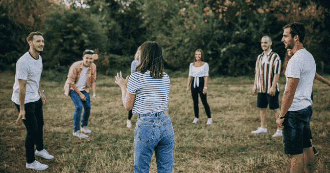Large group of employees playing games on a team building seminar outdoors