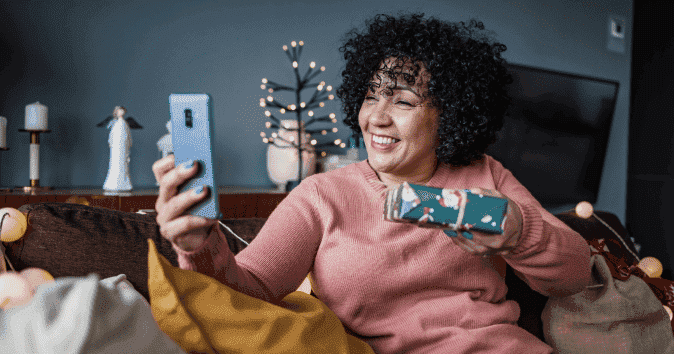A woman having a virtual holiday party to help get in the holiday spirit