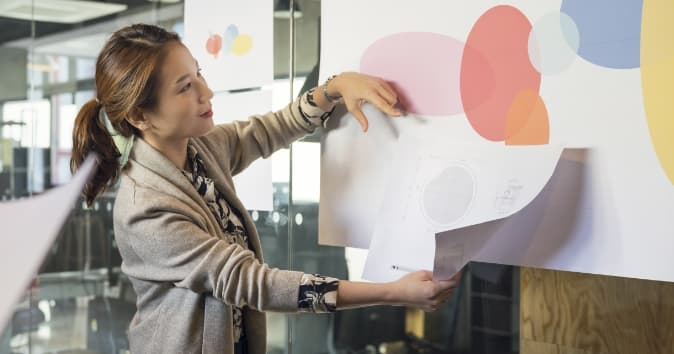 A woman looking at a graphic on the wall.