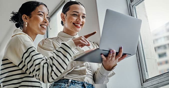 employees discussing holding the laptop in hand