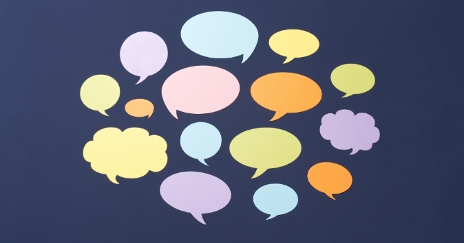 A collection of colorful speech bubbles in various shapes and sizes arranged on a dark background, meant to represent thank you messages and words of appreciation to employees.