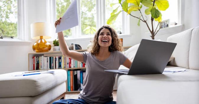 women sitting in front of her laptop and celebrating
