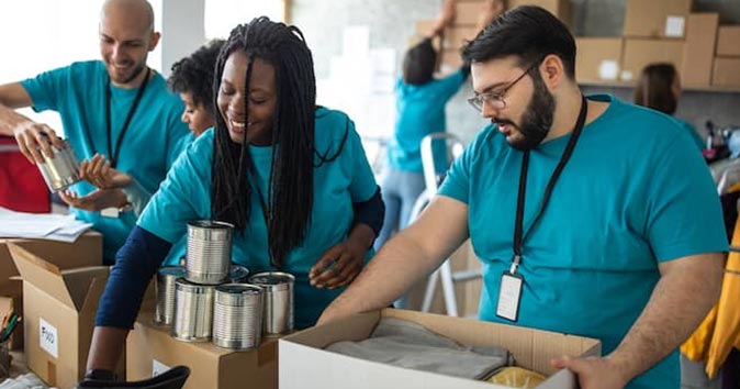 group of volunteers packing cardboard box