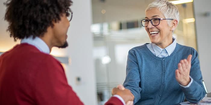 man and a woman shaking hands and smiling