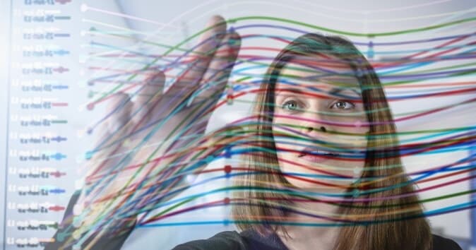 Woman touching a screen's data to move items, representing the application of machine learning in HR processes.