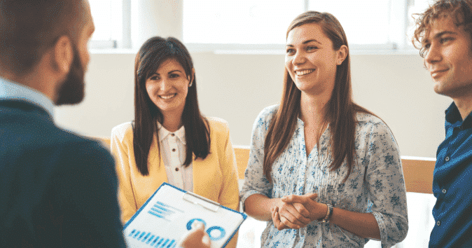 A young manager discussing the progress reports with his team"