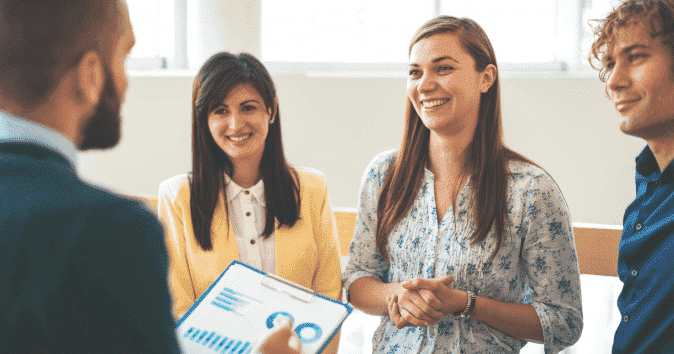 A young manager discussing the progress reports with his team"