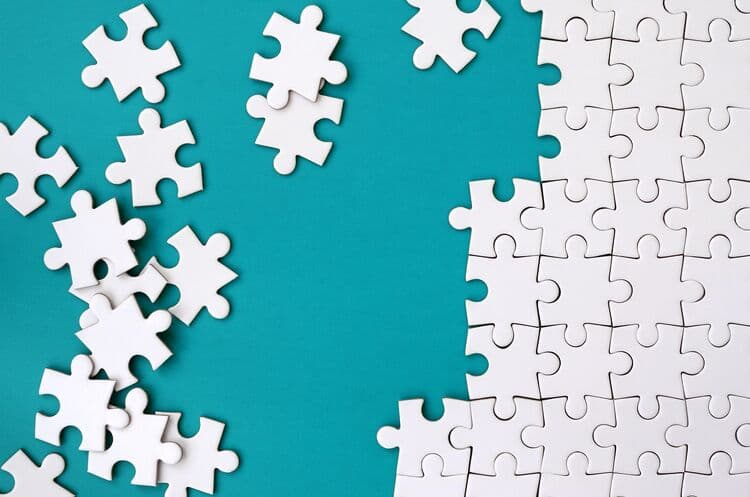 High angle view of jigsaw pieces over puzzle representing strategic-initiatives