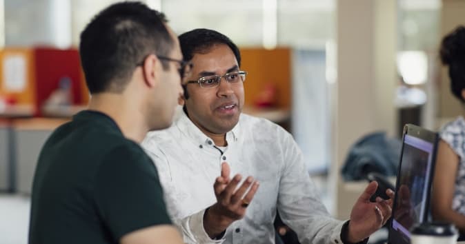 Man in conversation near laptop.
