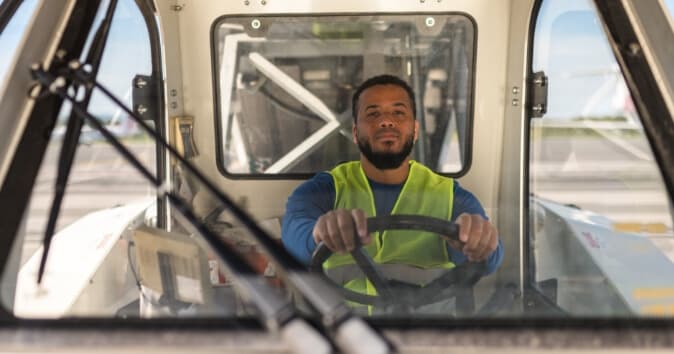 employee skills assessment of a man driving a passenger stair truck for an airplane.